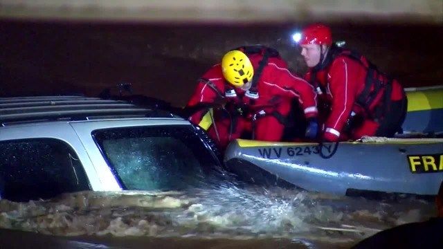 A driver trapped inside his SUV Friday night, as water rushed around it, left first responders with just minutes to take action. (Source: WCHS/WVAH/CNN)