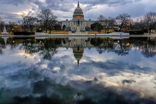 (AP Photo/J. David Ake). Clouds are reflected in the U.S. Capitol reflecting pool at daybreak in Washington as Day Three of the government shutdown continues, Monday, Jan. 22, 2018.