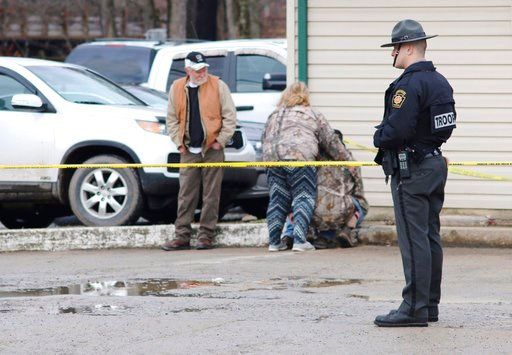 (Michael Palm /Herald-Standard via AP). An officer stands guard as people comfort each other near the scene of a fatal shooting at a car wash in Melcroft, Pa., Sunday, Jan. 28, 2018.