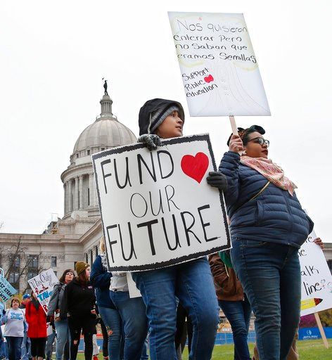(AP Photo/Sue Ogrocki). Teachers picket around the Oklahoma State Capitol in Oklahoma City, Monday, April 2, 2018, as teachers rally against low school funding.