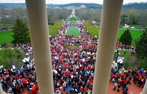 (AP Photo/Timothy D. Easley). Teachers from across Kentucky gather outside the state Capitol to rally for increased funding and to protest changes to their state funded pension system, Monday, April 2, 2018, in Frankfort, Ky.