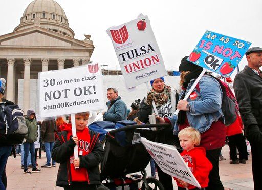 (AP Photo/Sue Ogrocki). Keagan Nedrow, left, and Reed Nedrow, bottom right, stand with their mother, Tara Nedrow, right, who teaches history at Union High School, and other teachers, during a teacher rally against low school funding.