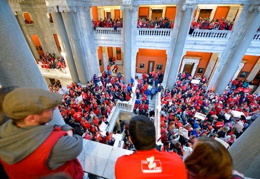 (AP Photo/Timothy D. Easley). Thousands of teachers from across Kentucky fill the state Capitol to rally for increased funding and to protest last minute changes to their state funded pension system, Monday, April 2, 2018, in Frankfort, Ky.
