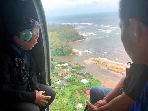 (Courtesy of Hawaii Governor's Office via AP). In this Monday, April 16, 2018, photo provided by the Office of the Governor, Hawaii, Hawaii Gov. David Ige, left, flies over the flood-damaged areas of the island of Kauai. Heavy rains on Kauai let up on ...