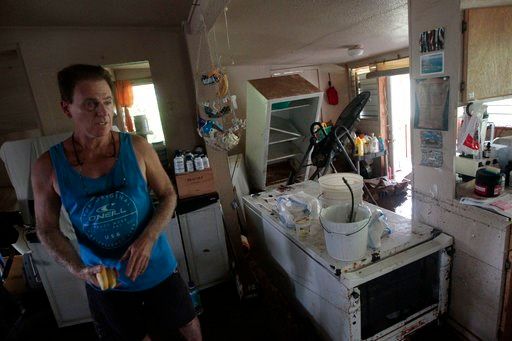 (Jamm Aquino/Honolulu Star-Advertiser via AP). Jeffrey Pollastrini stands inside his home on Monday, April 16, 2018, in Hanalei, Kauai. Heavy rain and flooding caused extensive damage to both the north and south parts of the island.
