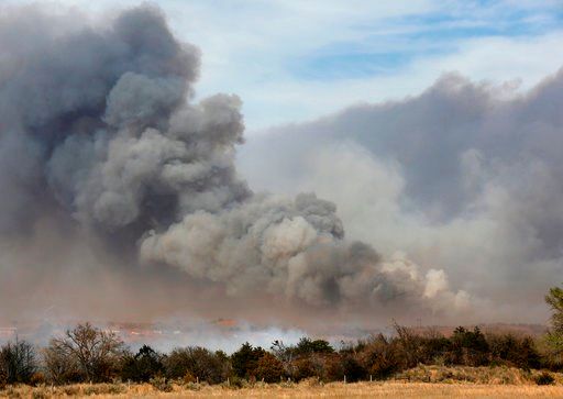 (Jim Beckel/The Oklahoman via AP). In this Tuesday, April 17, 2018, heavy smoke billows from burning trees in a farm field about 10 miles south of Seiling, Okla., along US Highway 183, on the east side of Dewey County as large wildfires ignited during ...