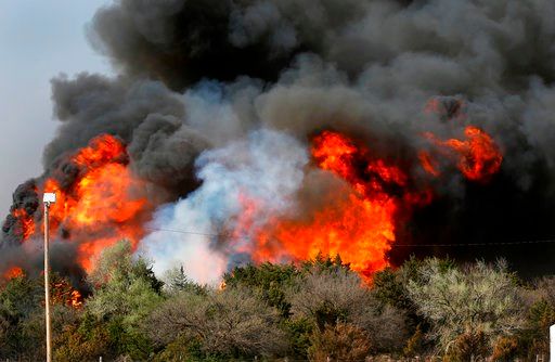 (Jim Beckel/The Oklahoman via AP). In this Tuesday, April 17, 2018, heavy smoke billows from burning trees after a wildfire broke out in a farm field along US Highway 183 about 10 miles south of Seiling, Okla.