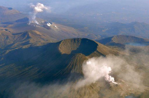 (Kyodo News via AP). CORRECTS YEAR - In this April 19, 2018, photo, volcanic smoke billows from Mt. Io, foreground, part of the Kirishima mountain range on Japan’s southern main island of Kyushu, taken over Ebino city, Miyazaki prefecture. The Meteorol...