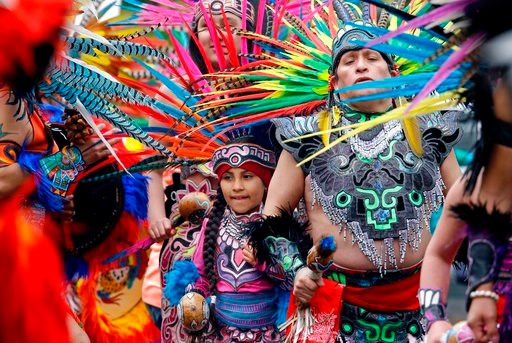 (AP Photo/Elaine Thompson, File). In this Monday, May 1, 2017, file photo, members of Ce Atl, an Aztec-inspired spiritual and cultural preservation group, dance near the front of a march for worker and immigrant rights at a May Day event.