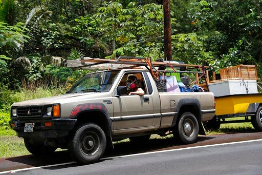 (AP Photo/Marco Garcia). While wearing an air filter mask, Laura Dawn drives her truck loaded with her possessions as she and her husband flee the lava eruption, Sunday, May 6, 2018, near Pahoa, HI. Their property is just below the active lava eruption...