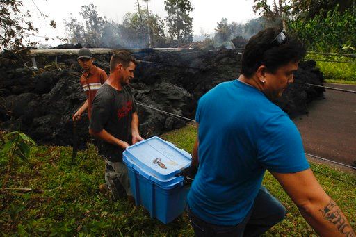 (Jamm Aquino/Honolulu Star-Advertiser via AP). Residents evacuate as lava continues to overrun Hookupu Street, Monday, May 7, 2018, in Pahoa, Hawaii. Hawaii's Kilauea volcano has destroyed homes and spewed lava hundreds of feet into the air, leaving ev...