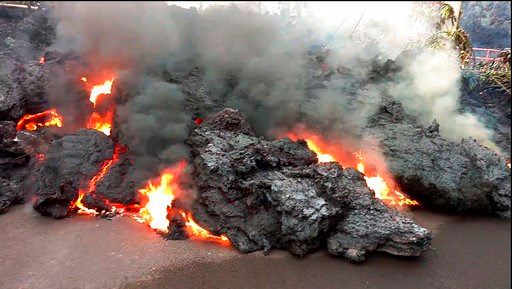 (Scott Wiggers/Apau Hawaii Tours via AP). In this photo from video a lava flow advancing down a road is seen from less than 10 feet away in the Leilani Estates subdivision near Pahoa on the island of Hawaii Monday, May 7, 2018. Kilauea volcano has dest...