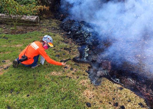 (U.S. Geological Survey via AP). In this Sunday, May 6, 2018 photo provided by the U.S. Geological Survey, a Hawaii Volcano Observatory (HVO) geologist collects samples of spatter for laboratory analysis in the Leilani Estates subdivision near Pahoa on...