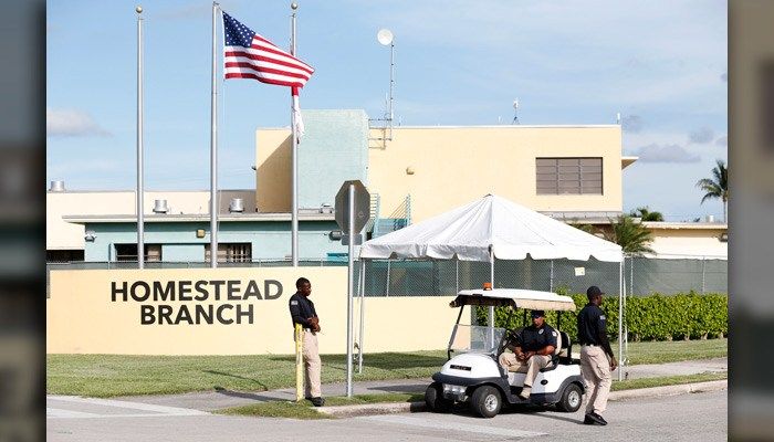 Security guards stand outside a former Job Corps site that now houses child immigrants Monday in Homestead, FL. An executive action may be in the works to end the practice, according to AP sources. (AP Photo/Wilfredo Lee)