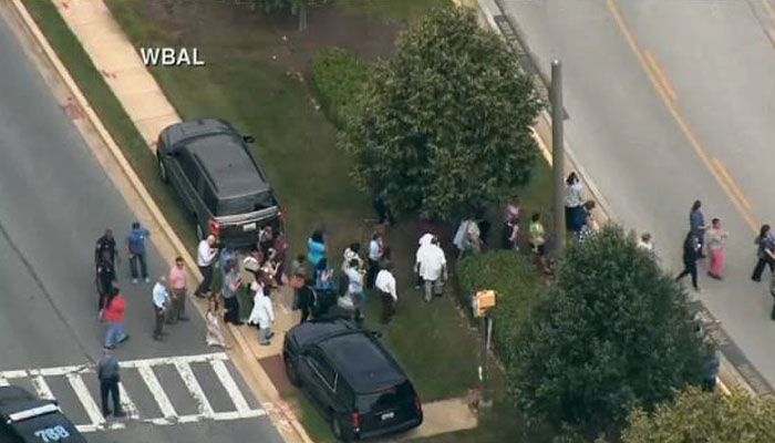 People evacuate from the office where a gunman opened fire at a newspaper in Annapolis. (Source: WBAL/CNN)
