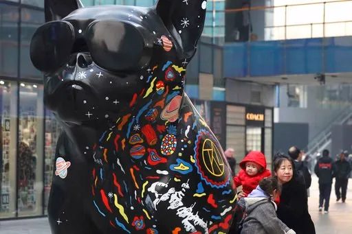 (AP Photo/Ng Han Guan). In this Thursday, Jan. 3, 2019, photo, a woman and children play near an art installation at a shopping mall in Beijing. A U.S. delegation led by deputy U.S. trade representative, Jeffrey D. Gerrish arrived in the Chinese capita...