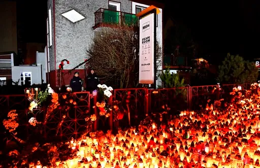 (AP Photo). Lights, flowers and toys are left outside the escape room entertainment site where five teenage girls died in a fire last week, in Koszalin, northern Poland, on Sunday, Jan. 6, 2019.  Sunday was designated a day of mourning and prayers in K...